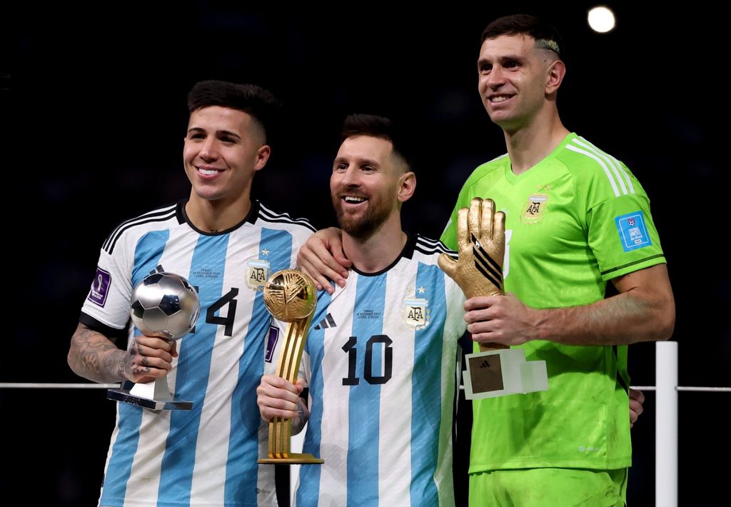La figura de la Selección, Lionel Messi, posa junto con los jugadores oriundos de Buenos Aires Enzo Fernández y Emiliano Martínez durante la entrega de premios del Mundial 2022.